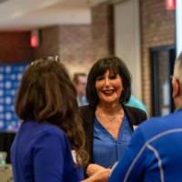 Two alums talking to President Mantella.